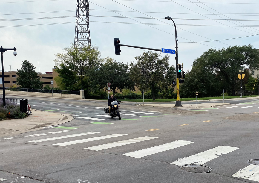 View of city intersection with green crosswalk striping
