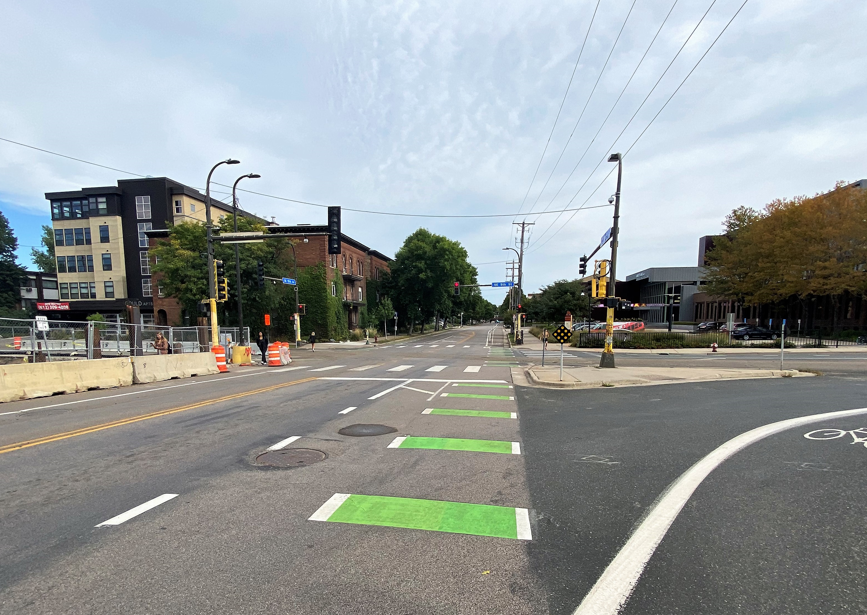 View of city intersection with green crosswalk striping