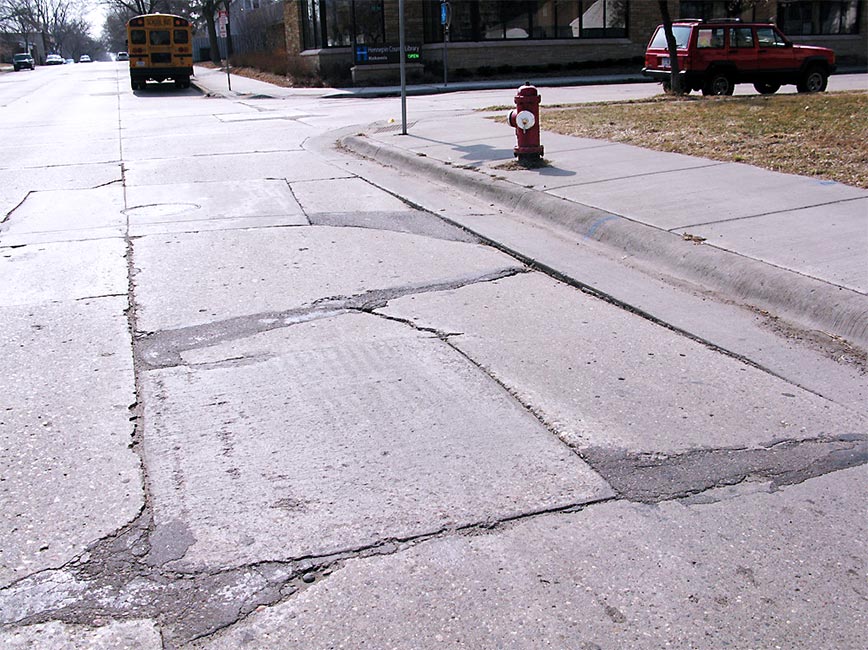 Photo of 34th ave. with cracked pavement before construction