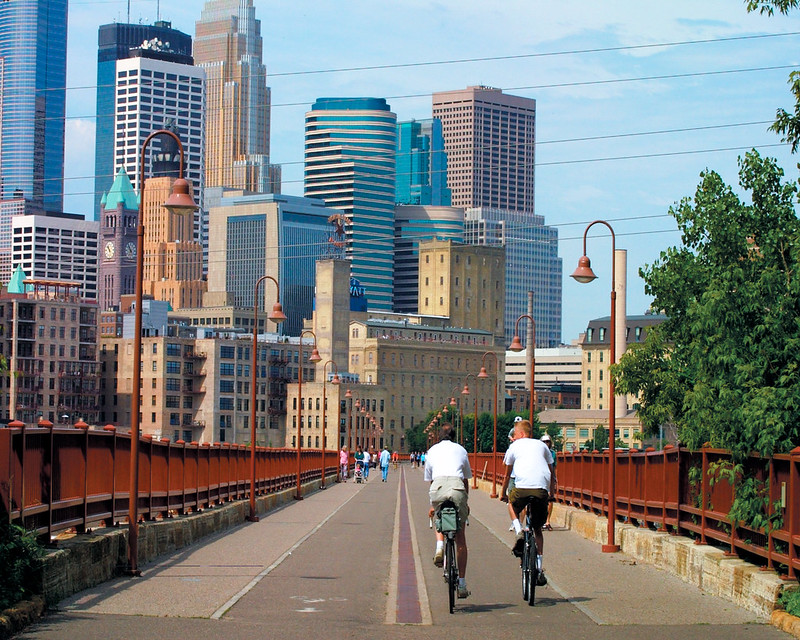 Two cyclists crossing a bridge in downtown Minneapolis.