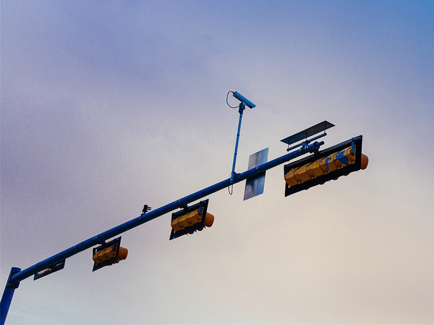 Image of a traffic light with camera mounted on top it