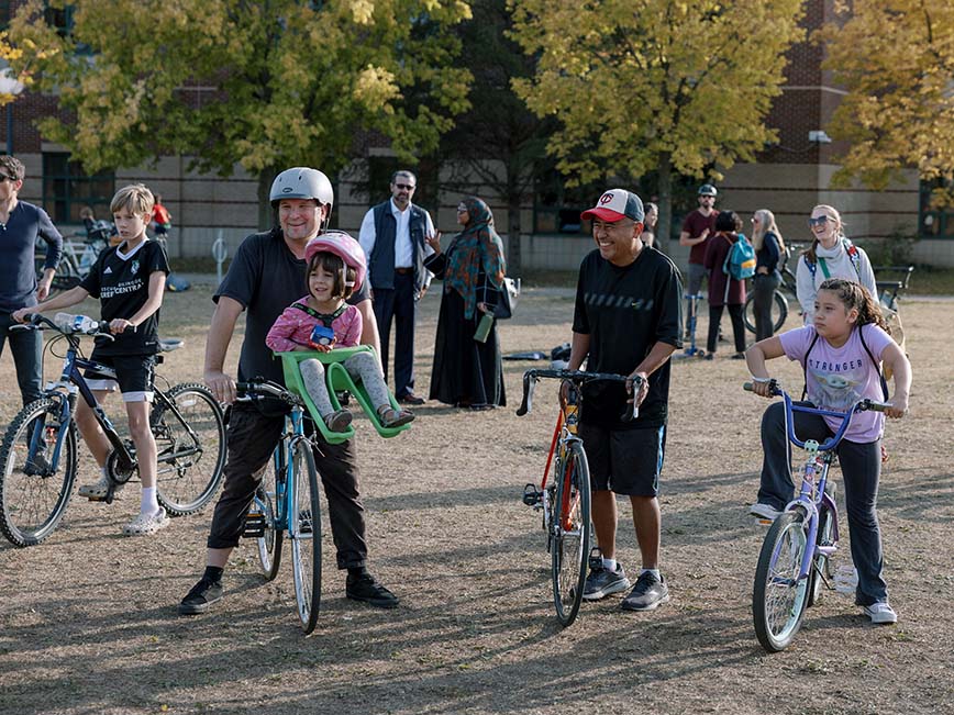 Smiling bicycle riders at an event.