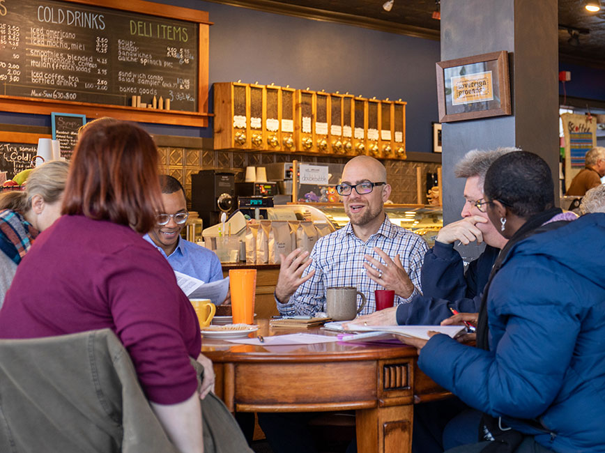 Council Member Jeremy Schroeder meeting with constituents in a coffee shop Council Member Jeremy Schroeder meeting with constituents in a coffee shop