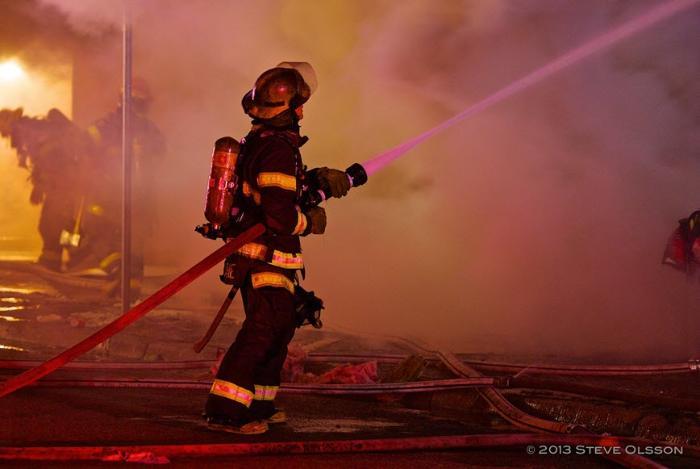 Minneapolis firefighter spraying water on a fire