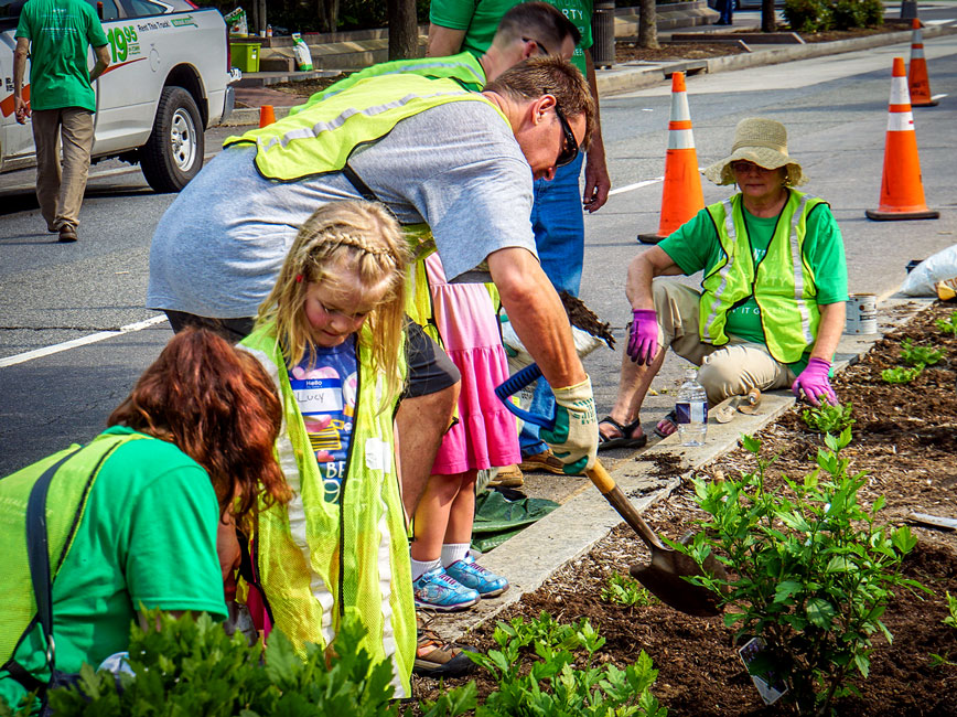 Children with adults doing community planting