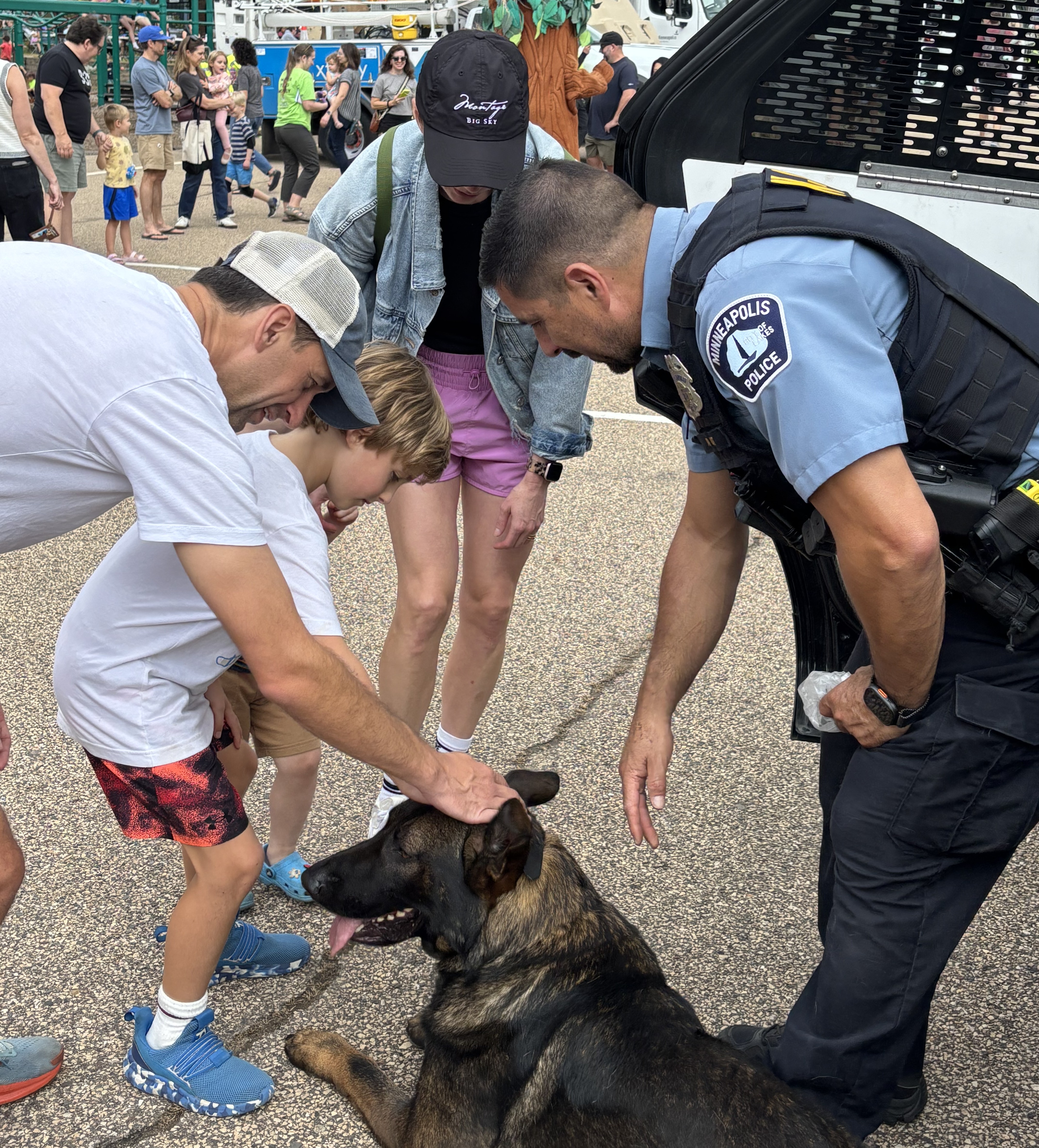 People petting a police canine. 