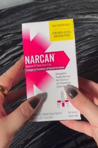 Hands holding a box of Narcan.