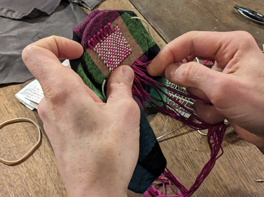 person mending a piece of clothing