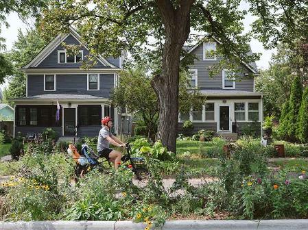 Riding a bike by a boulevard garden.