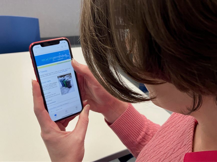 person reading recycling reminder email on their phone