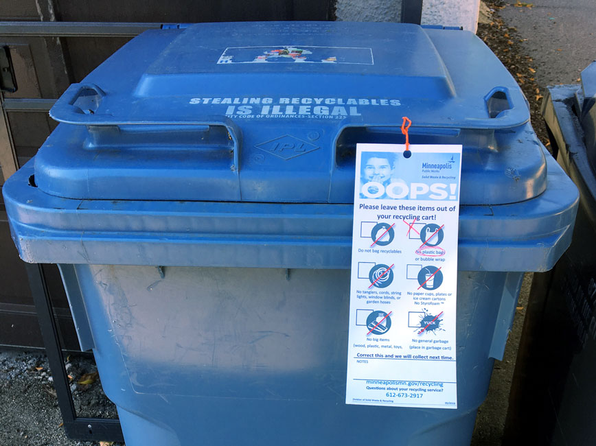 white educational tag on recycling cart