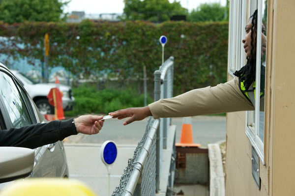 resident handing ID to scale attendant