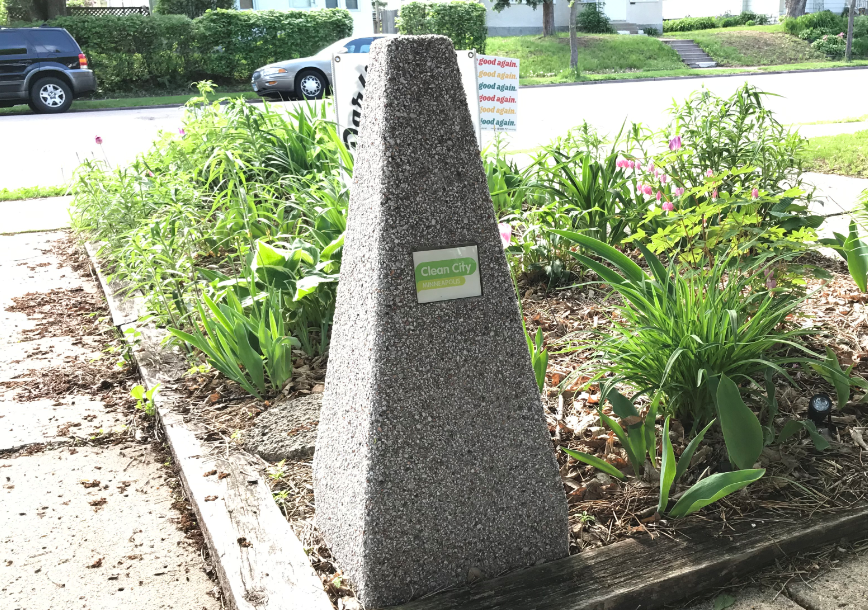 An ash receptacle with a Clean City label on it An ash receptacle with a Clean City label on it