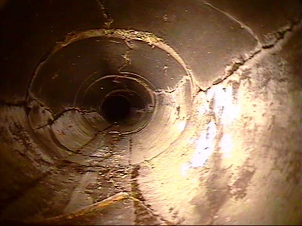 Interior view of storm pipe that is broken and deformed.