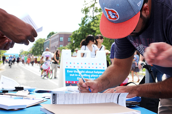 person registering to vote at an outdoor community event