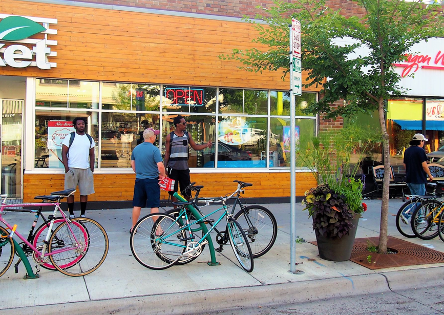 people standing around bikes people standing around bikes