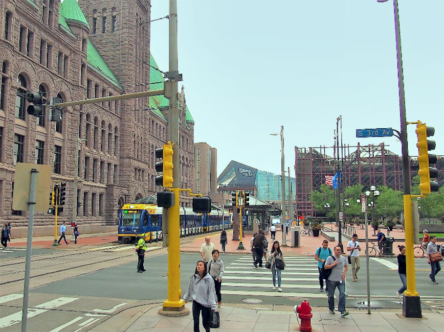 pedestrians walking near the city hall building in downtown Minneapolis
