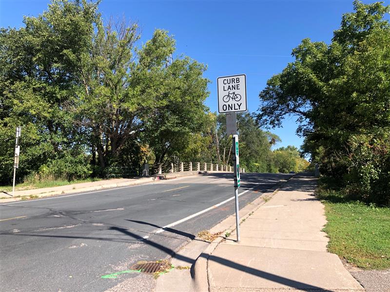 View of pavement and sidewalk on Cedar Lake Road bridge