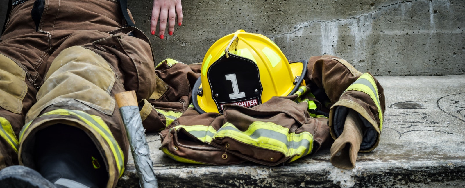 Yellow firefighter helmet and brown firefighter suit laying on the ground Yellow firefighter helmet and brown firefighter suit laying on the ground