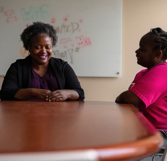Mildred Saulter and community outreach supervisor sitting across a table