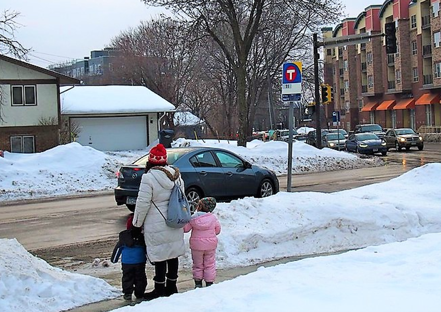 parent and children waiting to cross street