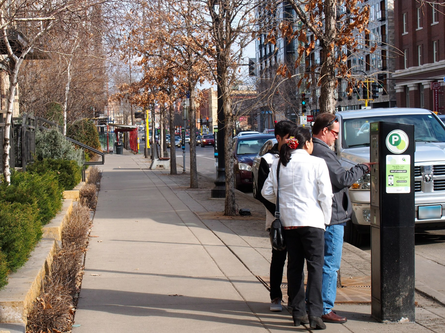 People paying at parking meter