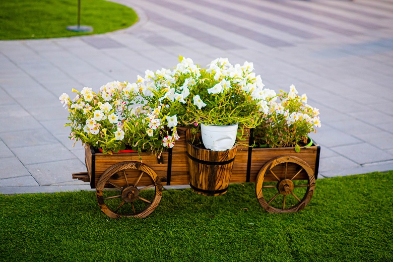 Flower cart with white and yellow flowers sitting on grass