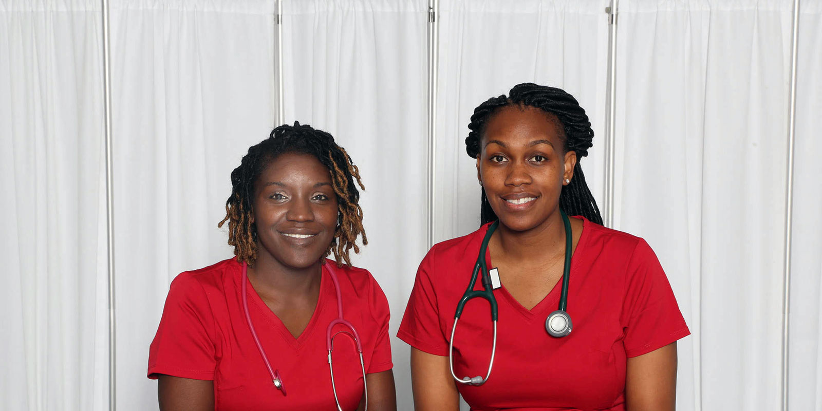 two nurses wearing red scrubs