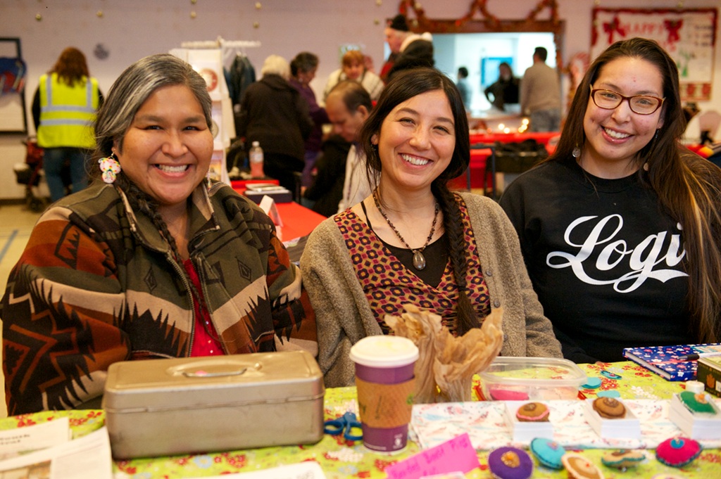 three smiling people sitting together at a table