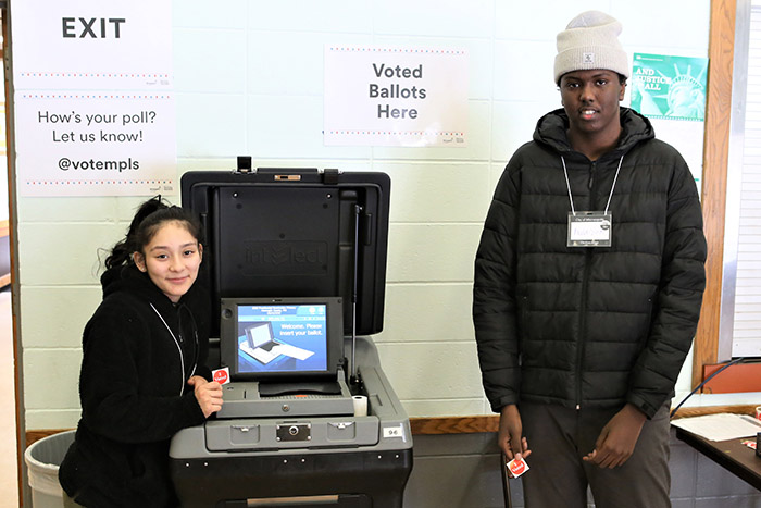 Two students helping at an election