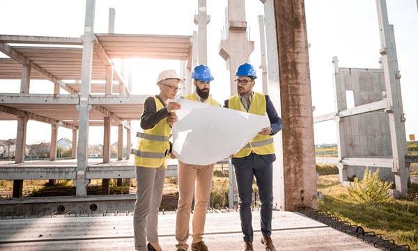 Three people standing in a construction site