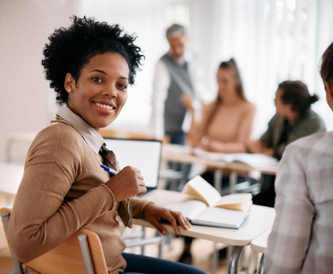 Smiling person at table with books