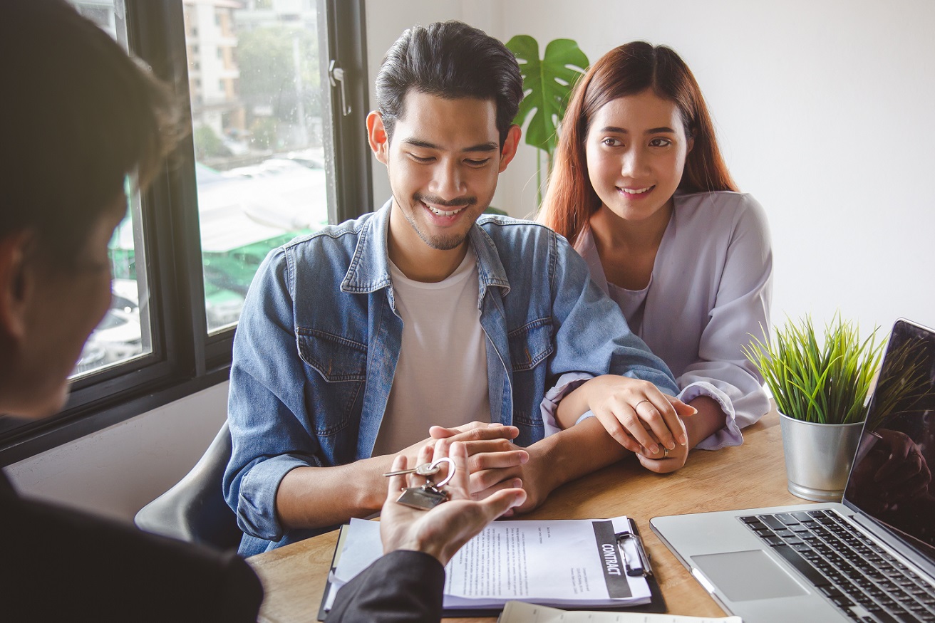two people smiling as they rent apartment