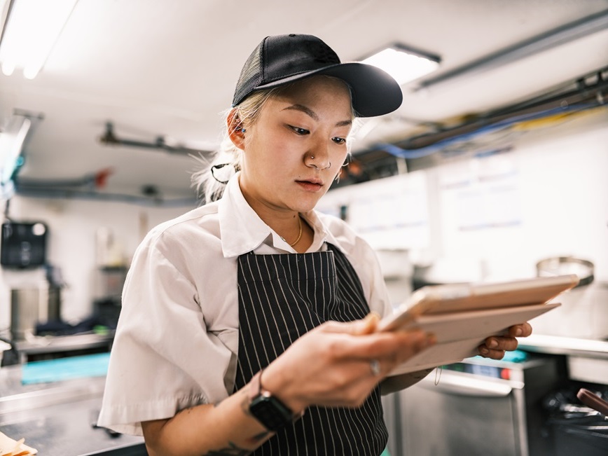Woman with a clipboard in a commercial kitchen