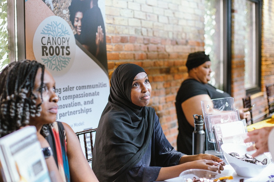 Three people sitting behind a table looking up at someone
