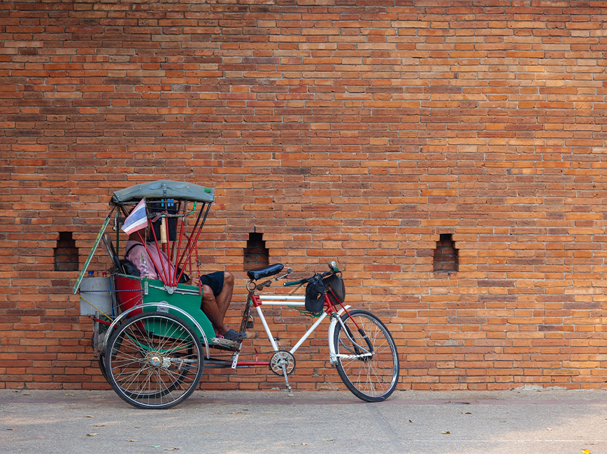 pedicab in front of brick wall