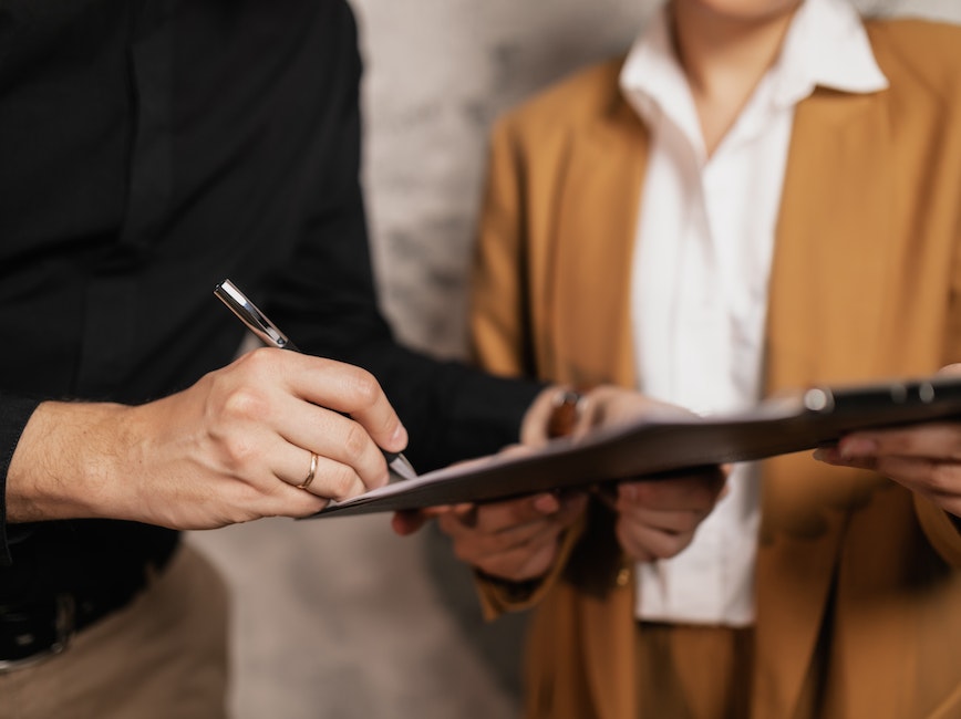 Person signing a piece of paper