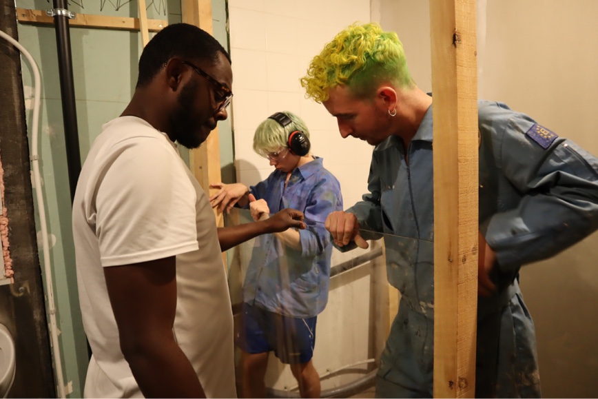 A diverse group of three people working on interior construction