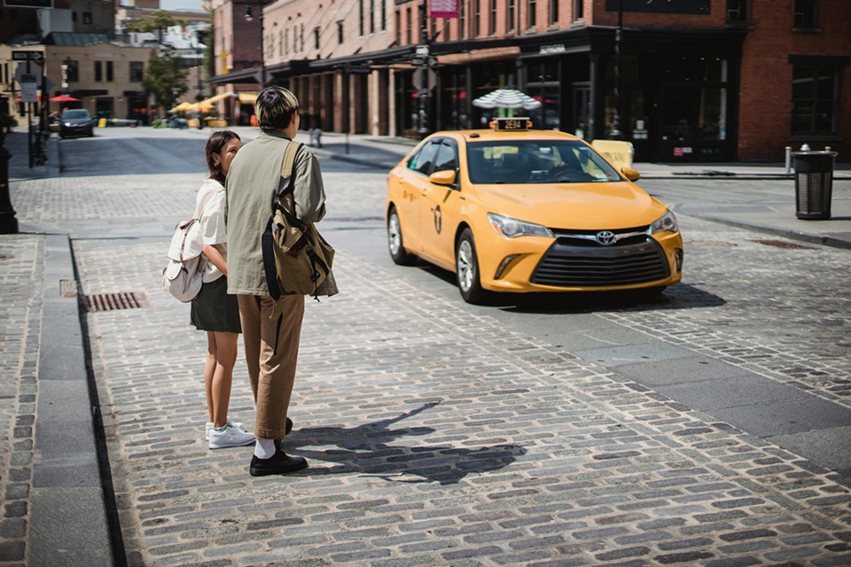 Young faceless couple standing on roadside in modern city