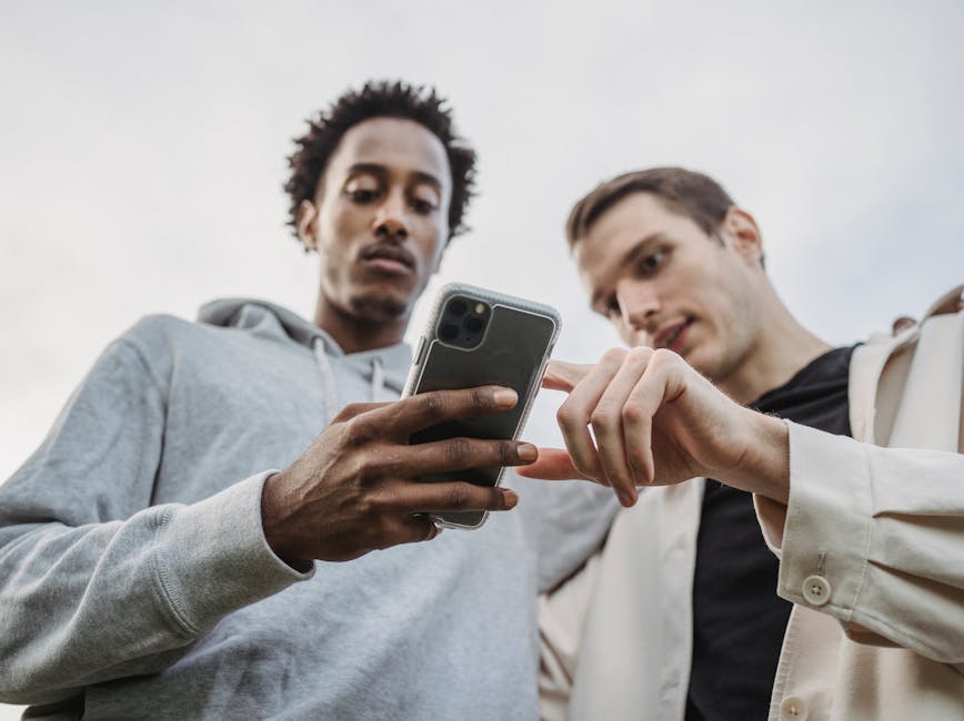 Two people staring at cell phone