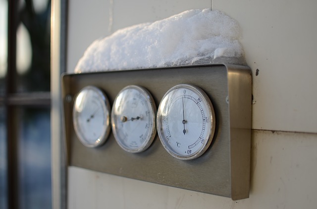 Electric meter on house with snow piled on top.