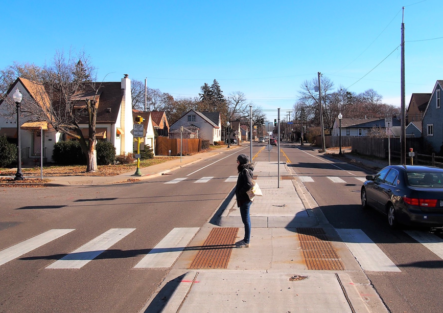Person waiting between crosswalks in Mpls Person waiting between crosswalks in Mpls